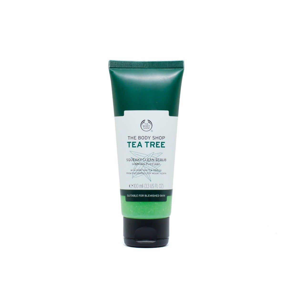 The Body Shop Tea Tree Clean Scrub in green tube with white cap on marble surface