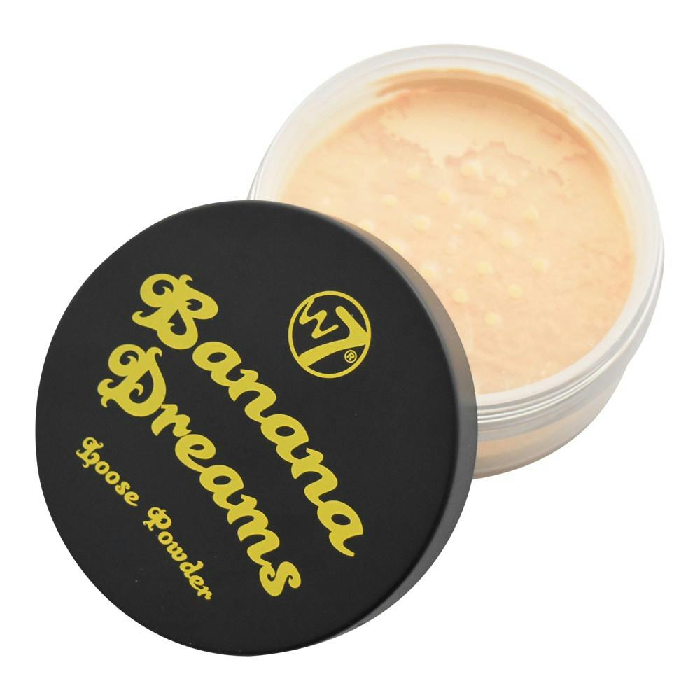 W7 Banana Dreams Loose Powder in its yellow cylindrical container with black lid, held in hand