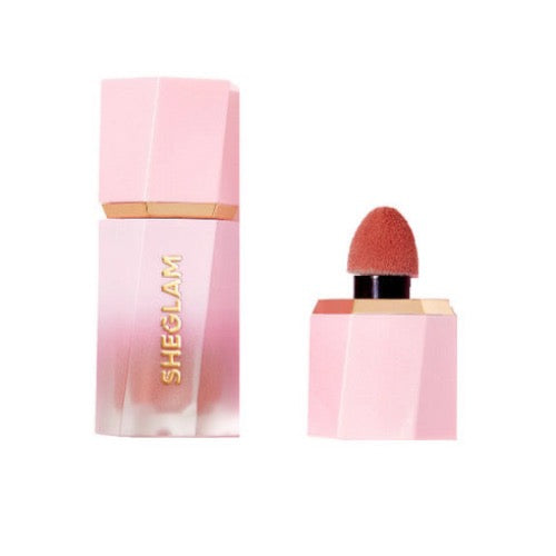 Sheglam Liquid Blush in shade Devoted Maven, a rose-pink liquid with shimmer in a transparent bottle with black pump dispenser.